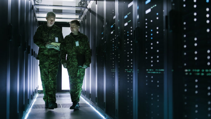 Military cybersecurity experts working with servers.