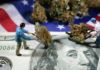Mini figurines hauling marijuana over money and American flag